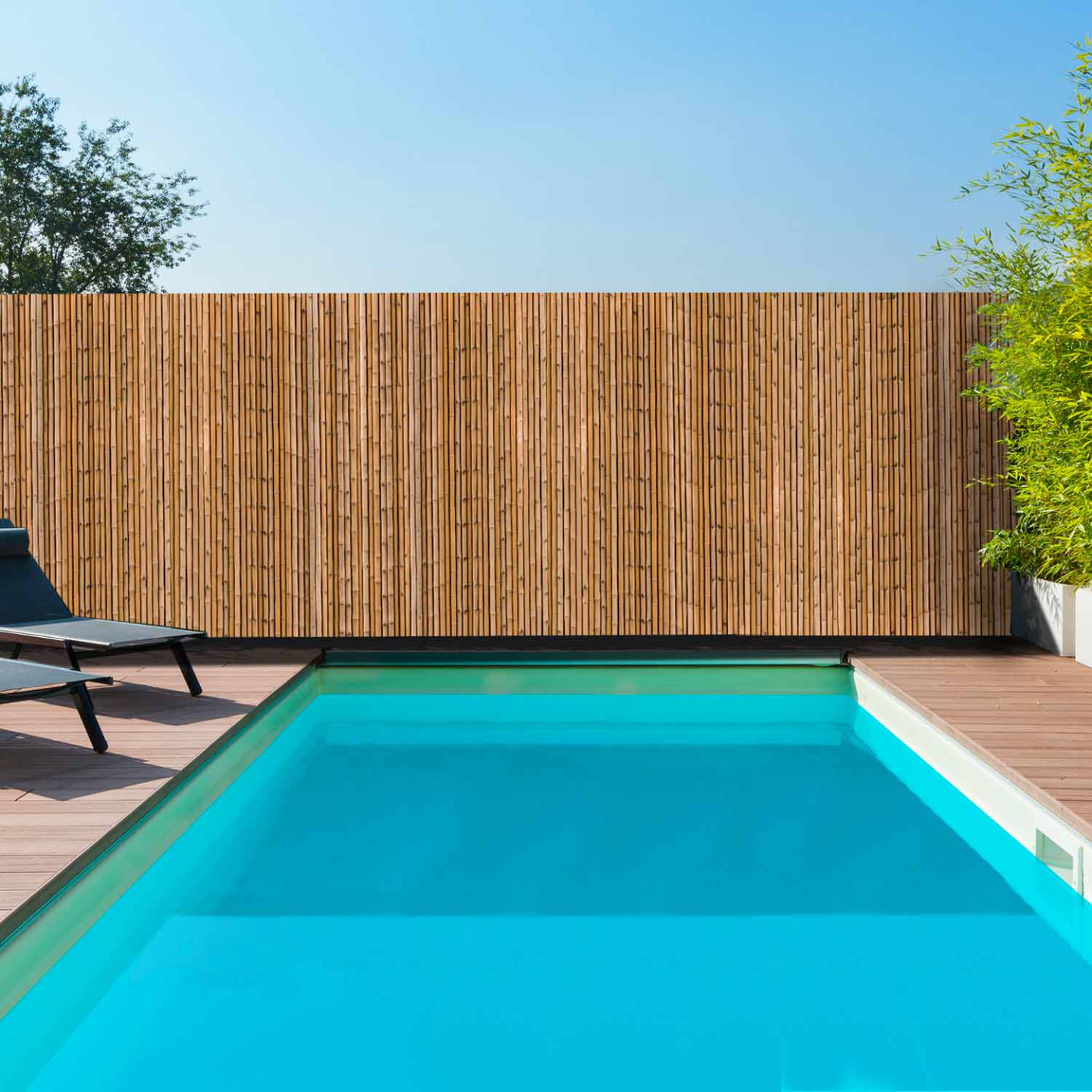 Brise-vue occultant effet bambou installé autour d’une piscine pour préserver l’intimité du jardin