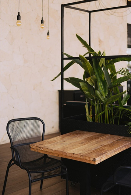 Une table industrielle avec une chaise noire.