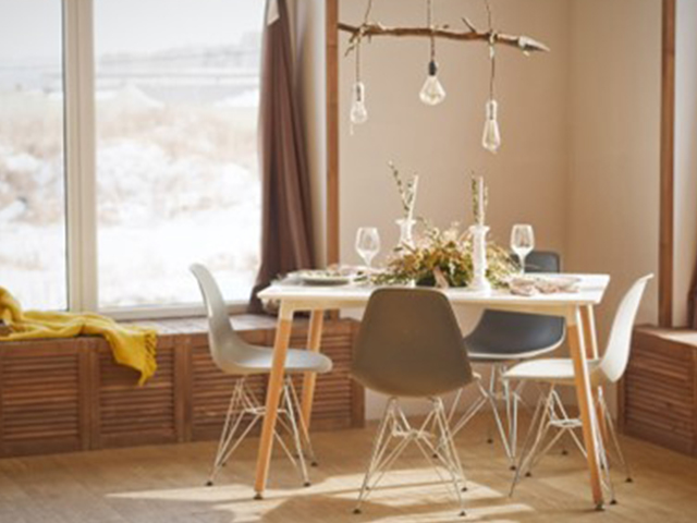 Des chaises disposées autour d’une table dans une salle à manger ensoleillée.