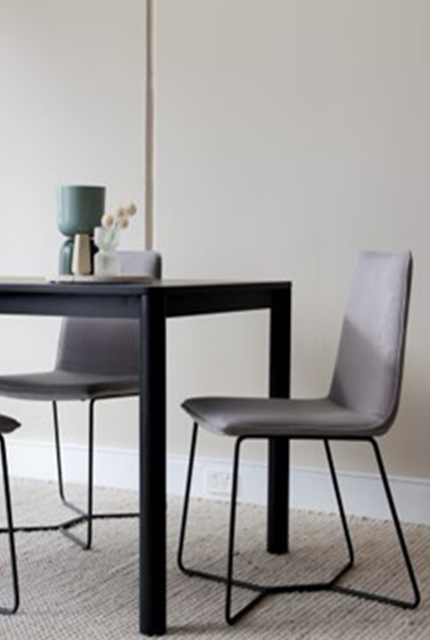 3 chaises tissus gris et métal noir autour d’une table