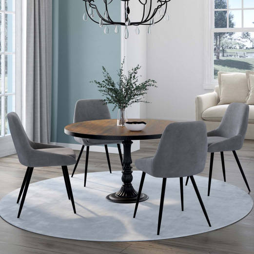 Une table en bois foncé ronde entourée de quatre chaises en velours gris