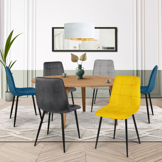 6 chaises en velours mix color autour d’une table ronde sur un tapis