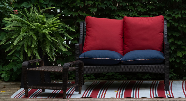 Un salon de jardin placé sur une petite terrasse en bois