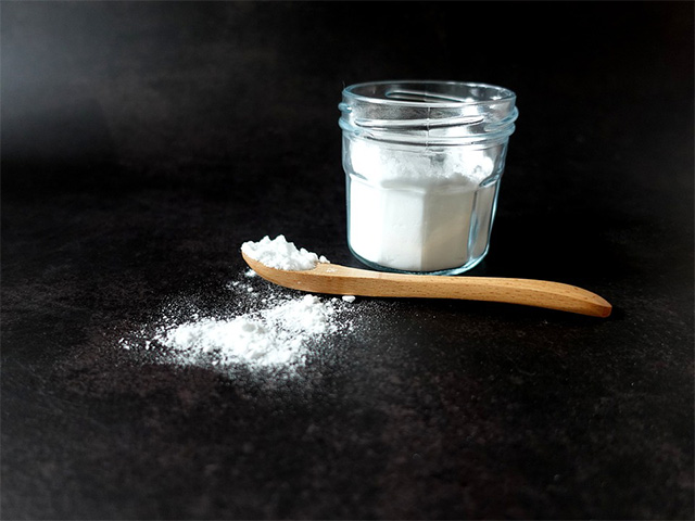 Poudre de bicarbonate de soude dans un pot et cuillère en bois