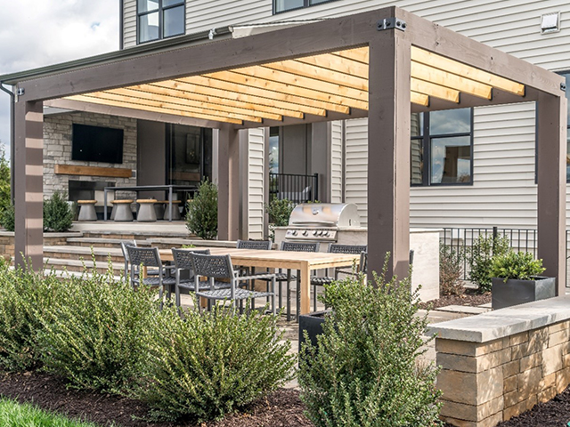 Une pergola en bois entourée d'arbustes