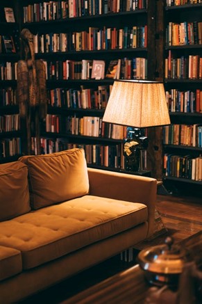 Dans un salon illuminé d’une couleur orangée, on trouve un canapé en velours côtelé