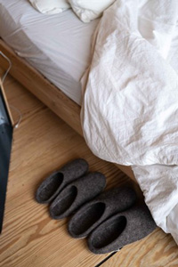 Une couette au grammage léger et des chaussons près du lit