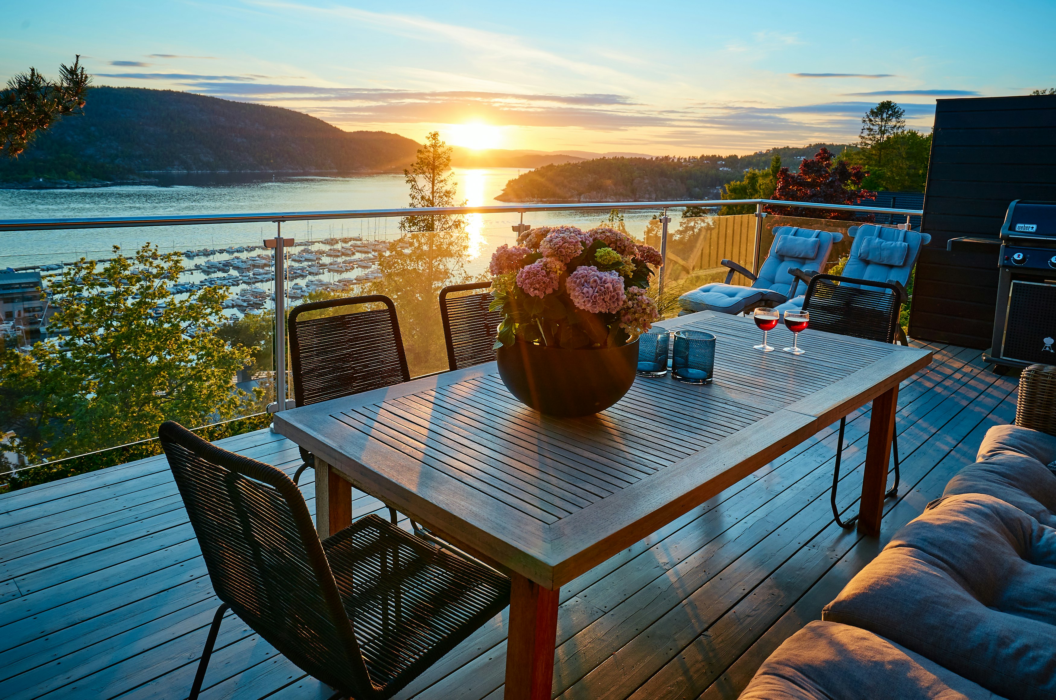 Salon de jardin en bois sur une terrasse aménagée avec des coussins et des accessoires pour une décoration extérieure chaleureuse et cosy.