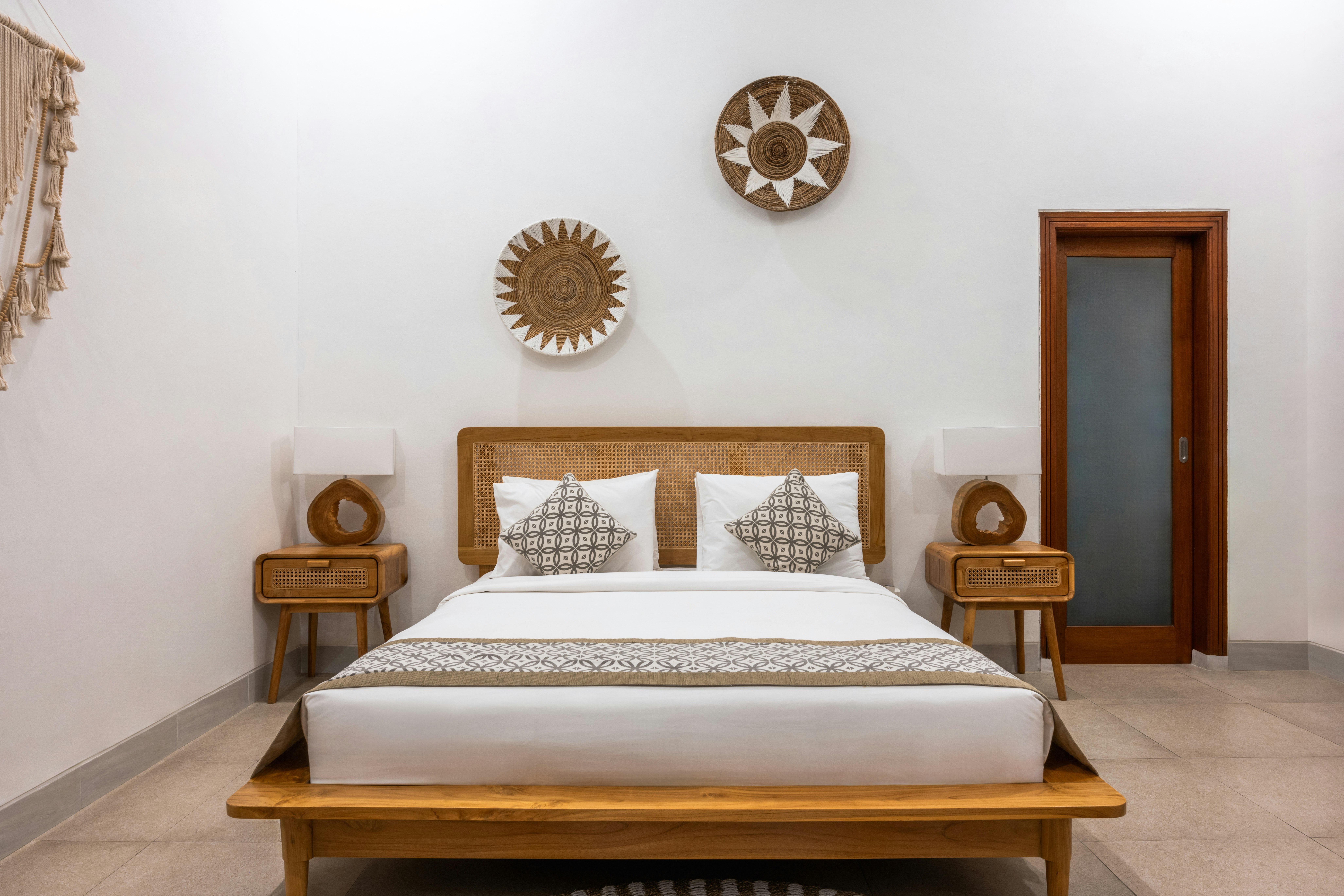 Lit double avec tête de lit en bois et cannage dans une chambre